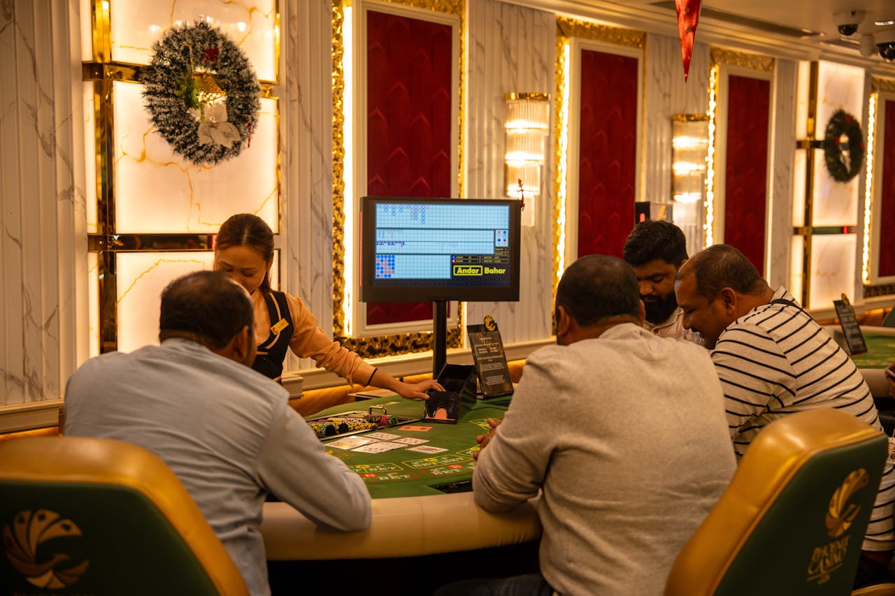 A group of adults playing at a casino table in Goa, India, captured indoors with festive decor.